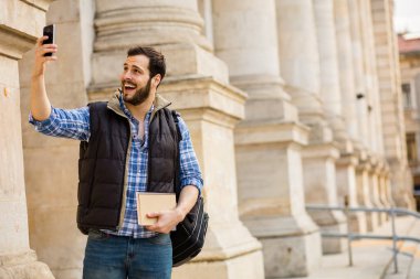 bir klasik BI ile binada arkasında sahip sırt çantası ile genç adam