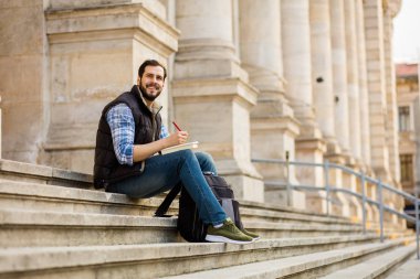 bir klasik BI ile binada arkasında sahip sırt çantası ile genç adam
