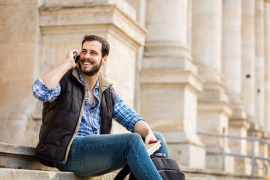 bir klasik BI ile binada arkasında sahip sırt çantası ile genç adam