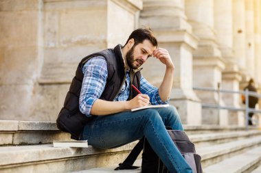 bir klasik BI ile binada arkasında sahip sırt çantası ile genç adam