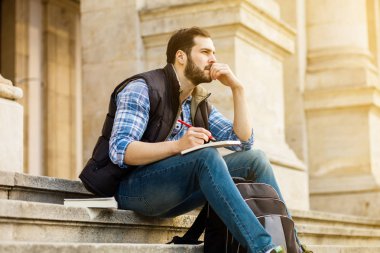 bir klasik BI ile binada arkasında sahip sırt çantası ile genç adam