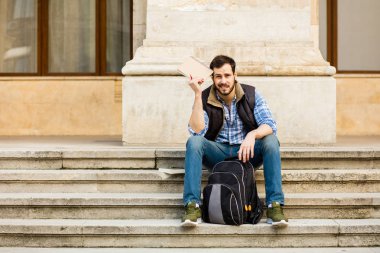 bir klasik BI ile binada arkasında sahip sırt çantası ile genç adam