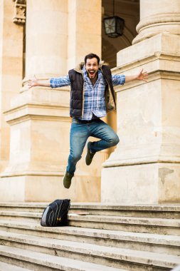 bir klasik BI ile binada arkasında sahip sırt çantası ile genç adam