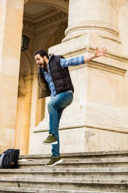 bir klasik BI ile binada arkasında sahip sırt çantası ile genç adam