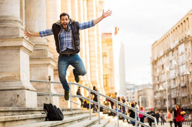 bir klasik BI ile binada arkasında sahip sırt çantası ile genç adam