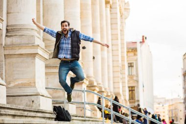 bir klasik BI ile binada arkasında sahip sırt çantası ile genç adam