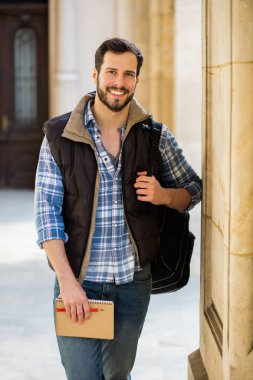 bir klasik BI ile binada arkasında sahip sırt çantası ile genç adam