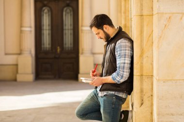 bir klasik BI ile binada arkasında sahip sırt çantası ile genç adam