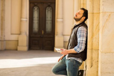 bir klasik BI ile binada arkasında sahip sırt çantası ile genç adam