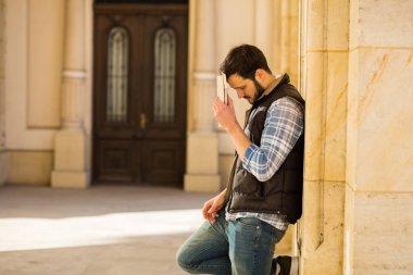 bir klasik BI ile binada arkasında sahip sırt çantası ile genç adam