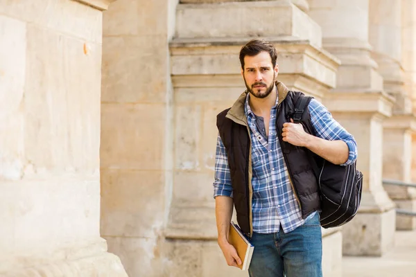 Young man with backpack having behind a classic building with bi — Stock Photo, Image