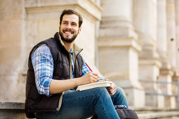 Junger Mann mit Rucksack, der hinter einem klassischen Gebäude mit — Stockfoto