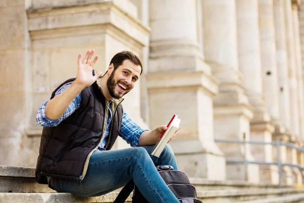 Junger Mann mit Rucksack, der hinter einem klassischen Gebäude mit — Stockfoto