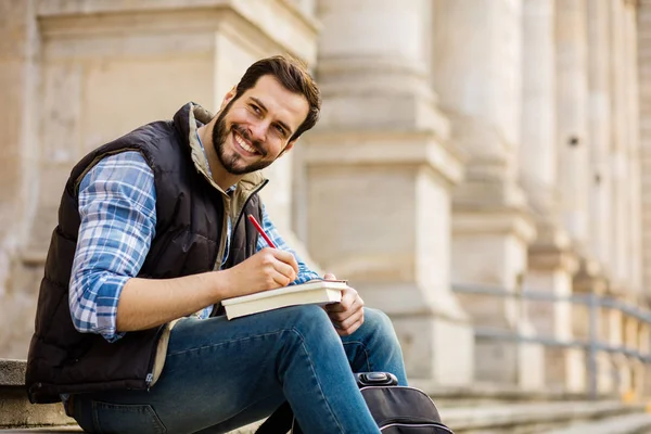 Joven con mochila que tiene detrás de un edificio clásico con bi — Foto de Stock