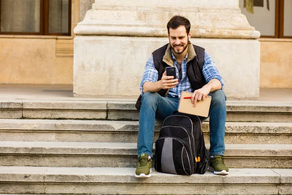 Junger Mann mit Rucksack, der hinter einem klassischen Gebäude mit — Stockfoto