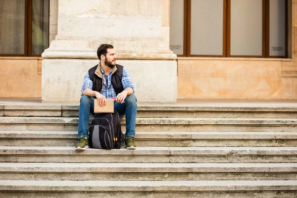 Joven con mochila que tiene detrás de un edificio clásico con bi — Foto de Stock