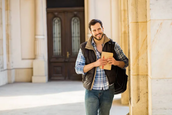 Joven con mochila que tiene detrás de un edificio clásico con bi — Foto de Stock