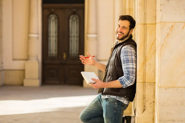 Joven con mochila que tiene detrás de un edificio clásico con bi — Foto de Stock