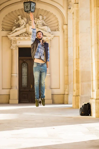 Młody człowiek z plecakiem po za klasycznym budynku z bi — Zdjęcie stockowe