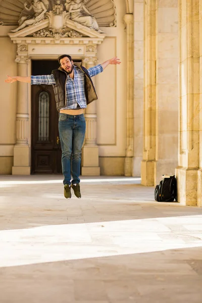 Joven con mochila que tiene detrás de un edificio clásico con bi — Foto de Stock