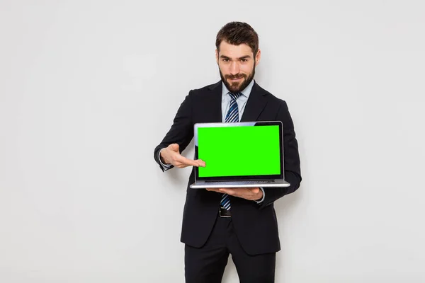 Eleganter Mann im Anzug mit Krawatte hält einen Laptop auf weißem Hintergrund — Stockfoto