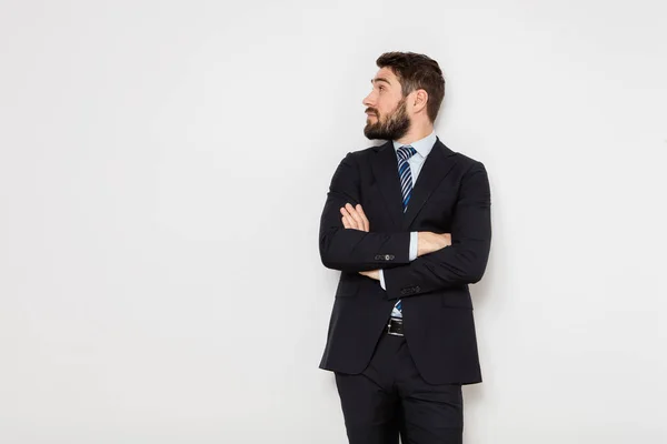 Elegante uomo in giacca e cravatta sulla parete bianca — Foto Stock