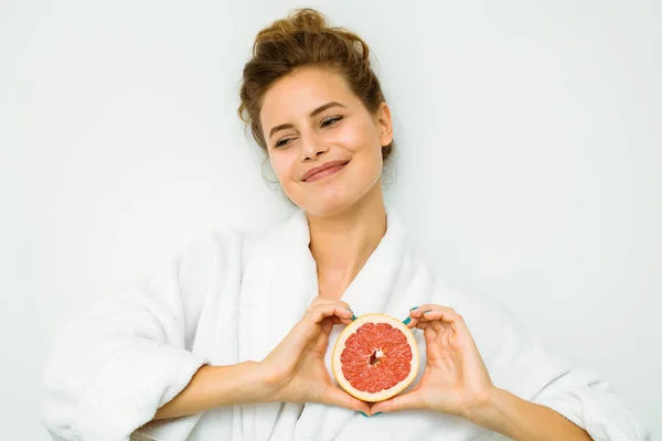 Nő a fehér fürdőlepedő, egy nagy grapefruit — Stock Fotó