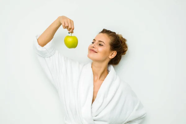 Femme en serviette de bain blanche tenant pomme dans les mains — Photo