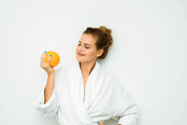 Frau in weißem Badetuch mit einer großen Grapefruit — Stockfoto