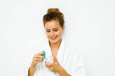 bir cilt kremi holding beyaz banyo havlusu kadında