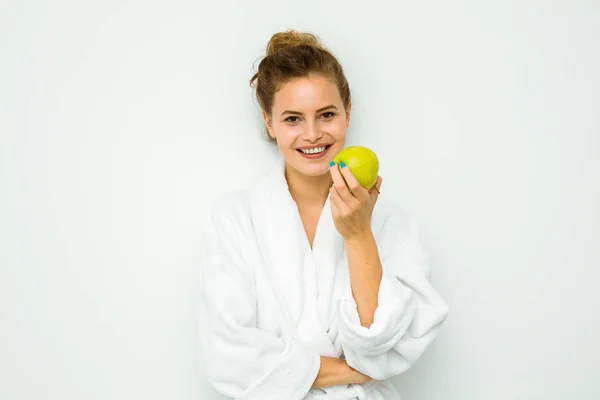 Frau in weißem Badetuch isst und Apfel — Stockfoto