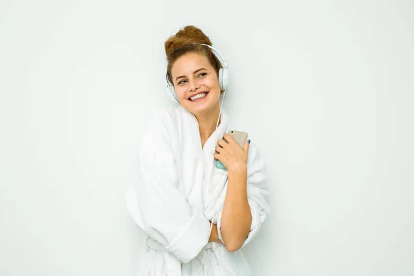 Žena v bílých froté ručníky s hudbou v uších — Stock fotografie