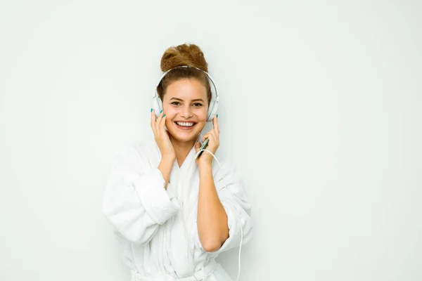 Mujer en toalla de baño blanca con música en los oídos — Foto de Stock