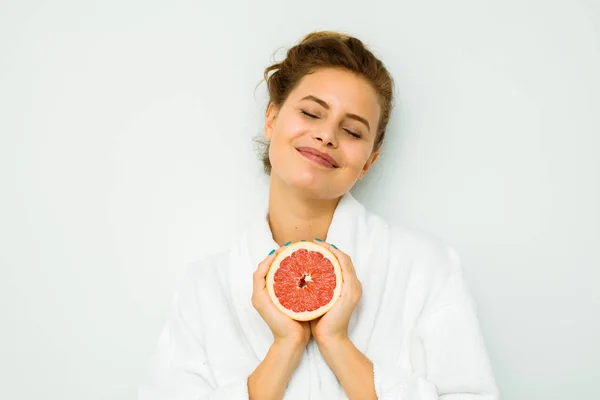 Žena v bílých osuška s velkým grapefruit — Stock fotografie