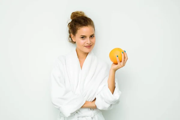 Femme en serviette de bain blanche avec un gros pamplemousse — Photo