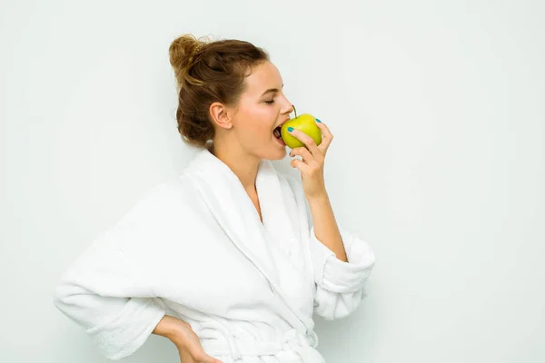 Mulher em toalha de banho branca comendo e maçã — Fotografia de Stock