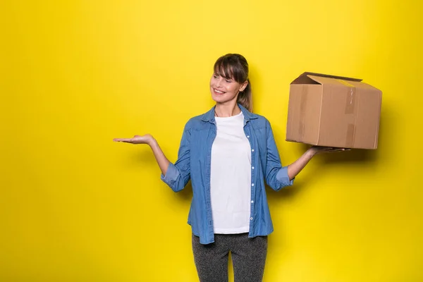 Bonita Mulher Fundo Amarelo Com Caixa Papelão Movimento — Fotografia de Stock