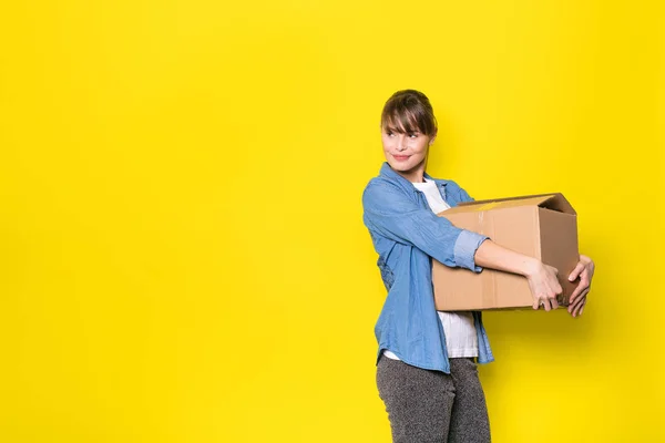 Όμορφη Γυναίκα Που Στέκεται Πάνω Κίτρινο Φόντο Μετακίνηση Κουτί Από — Φωτογραφία Αρχείου