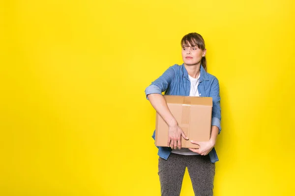 Bonita Mulher Fundo Amarelo Com Caixa Papelão Movimento — Fotografia de Stock