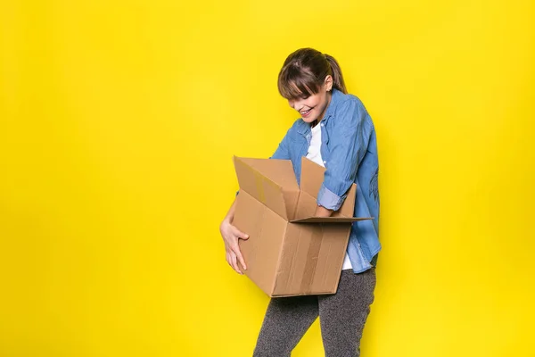 Happy Woman Looking Cardboard Box New Stuff Yellow Background — Stock Photo, Image