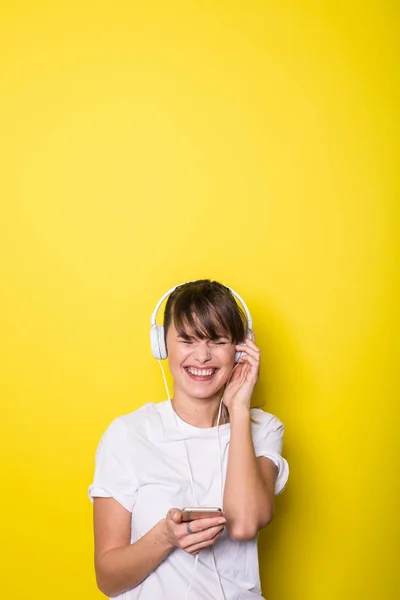 Молодая Красивая Женщина Слушает Музыку Белыми Наушниками Изолированном Желтом Фоне — стоковое фото