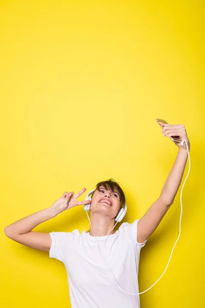 Молодая Красивая Женщина Слушает Музыку Белыми Наушниками Изолированном Желтом Фоне — стоковое фото