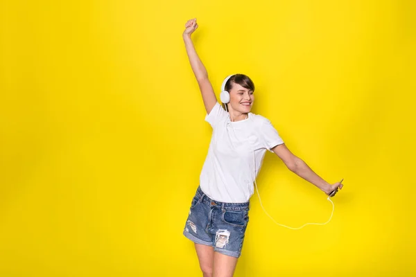 Ακούγοντας Μουσική Νεαρή Και Όμορφη Γυναίκα Λευκά Ακουστικά Απομονωμένες Κίτρινο — Φωτογραφία Αρχείου
