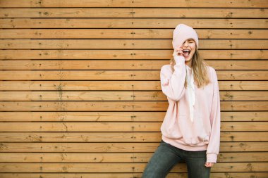 ahşap arka plan üzerinde pembe kapşonlu güzel genç kadın