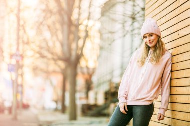 ahşap arka plan üzerinde pembe kapşonlu güzel genç kadın