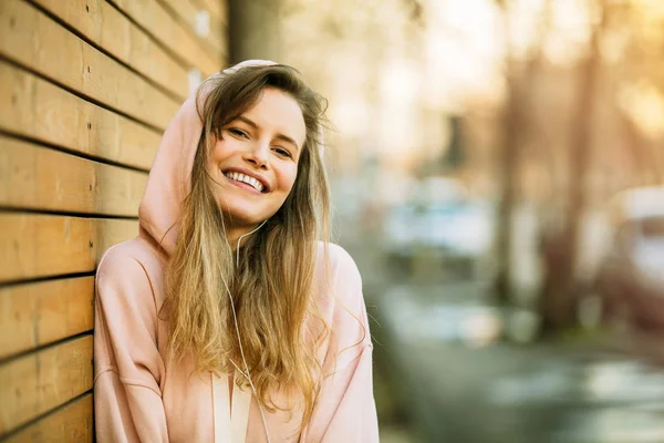 Fresco joven mujer en rosa sudadera con capucha sobre fondo de madera — Foto de Stock