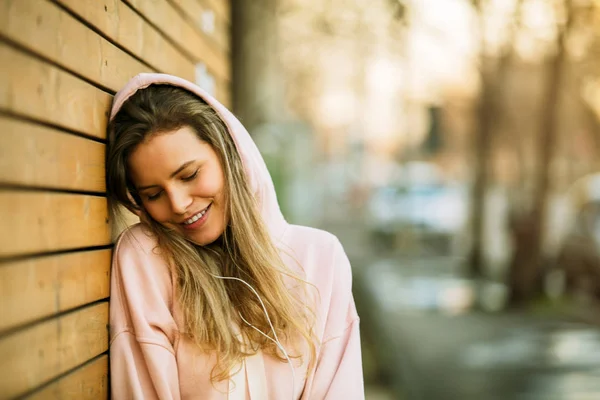 Fresco joven mujer en rosa sudadera con capucha sobre fondo de madera — Foto de Stock