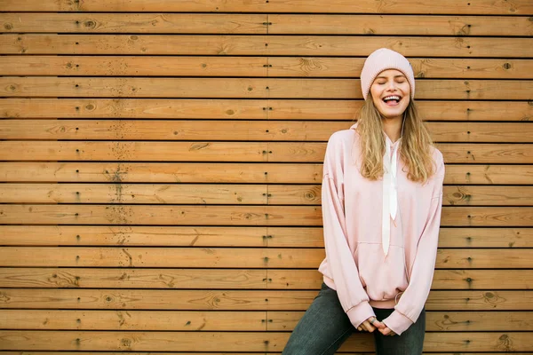 Fresco joven mujer en rosa sudadera con capucha sobre fondo de madera — Foto de Stock