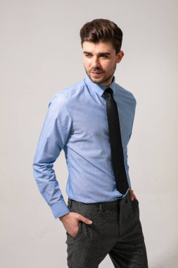 Yakışıklı ve genç adam, işe gitmek için resmi bir kıyafet giyiyor.