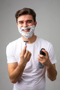 Yüzünde köpük olan bir adamın portresi kesilecek olan sakalını düşünüyor.